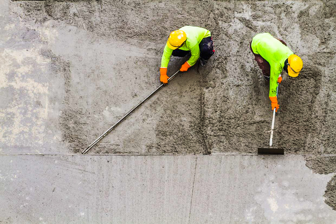 Worker takes concrete a shovel.